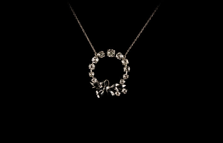 18ct gold circular old cut diamond set pendant with bow design